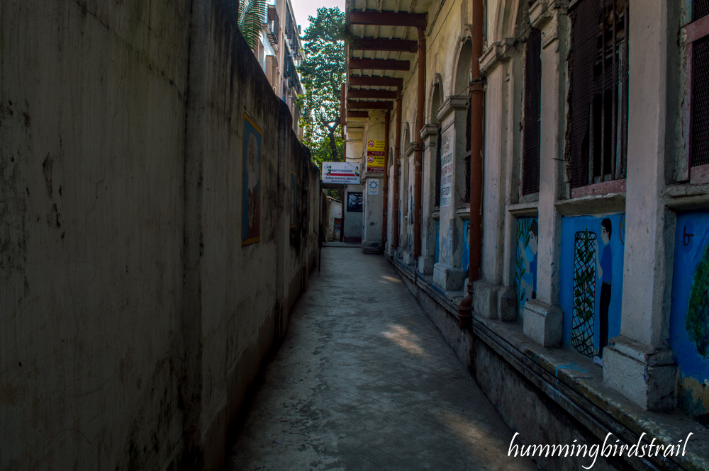 The alleyway running by the row of classrooms. The space has been constricted by the construction of multi-storeyed houses on neighbouring plots. The number of students studying in the school is a mere 156 which is evident by the deserted look while school is running